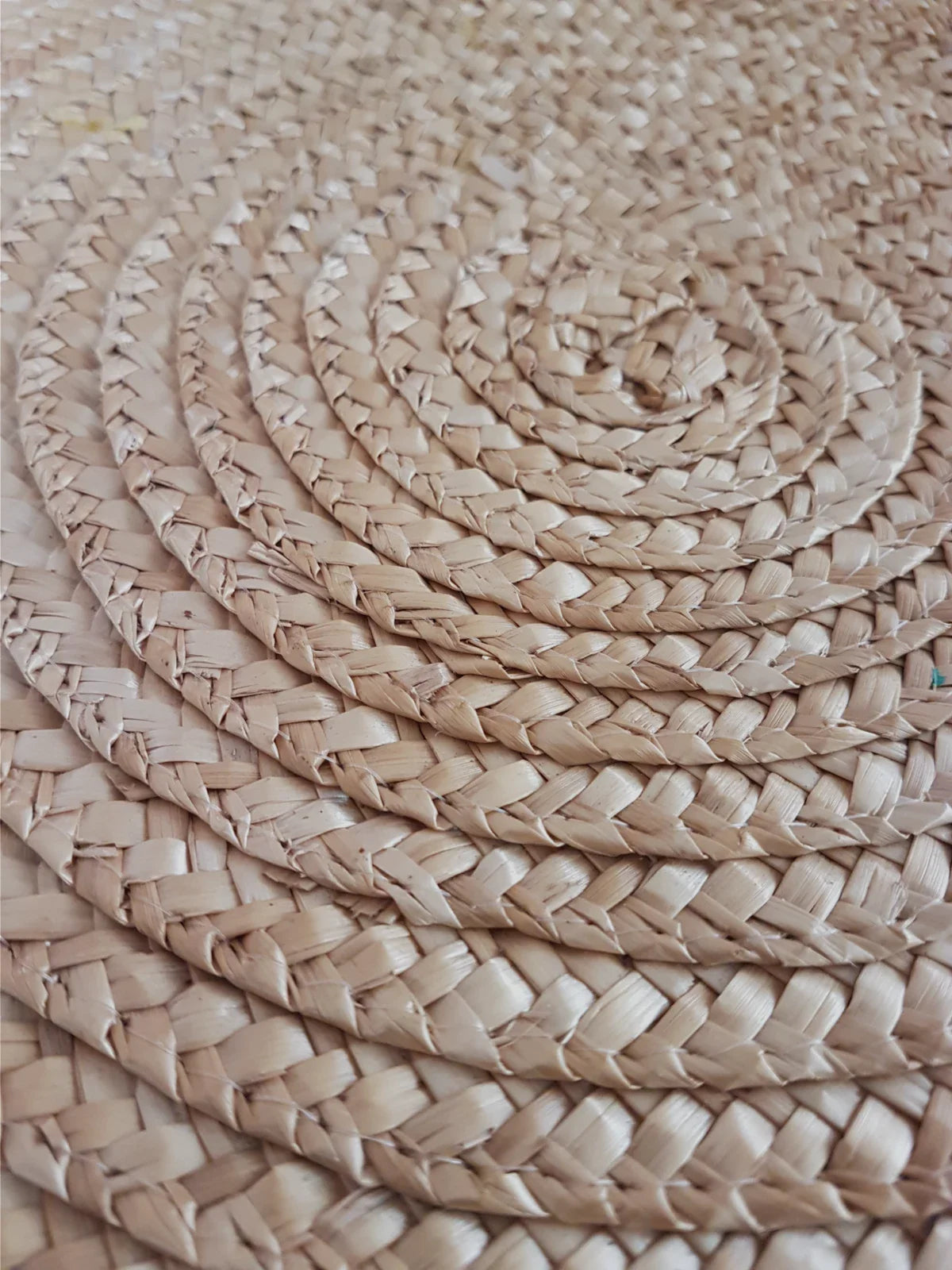 Close-up of a round jute rug with a tightly woven spiral pattern, showcasing its natural fiber texture and eco-friendly design.