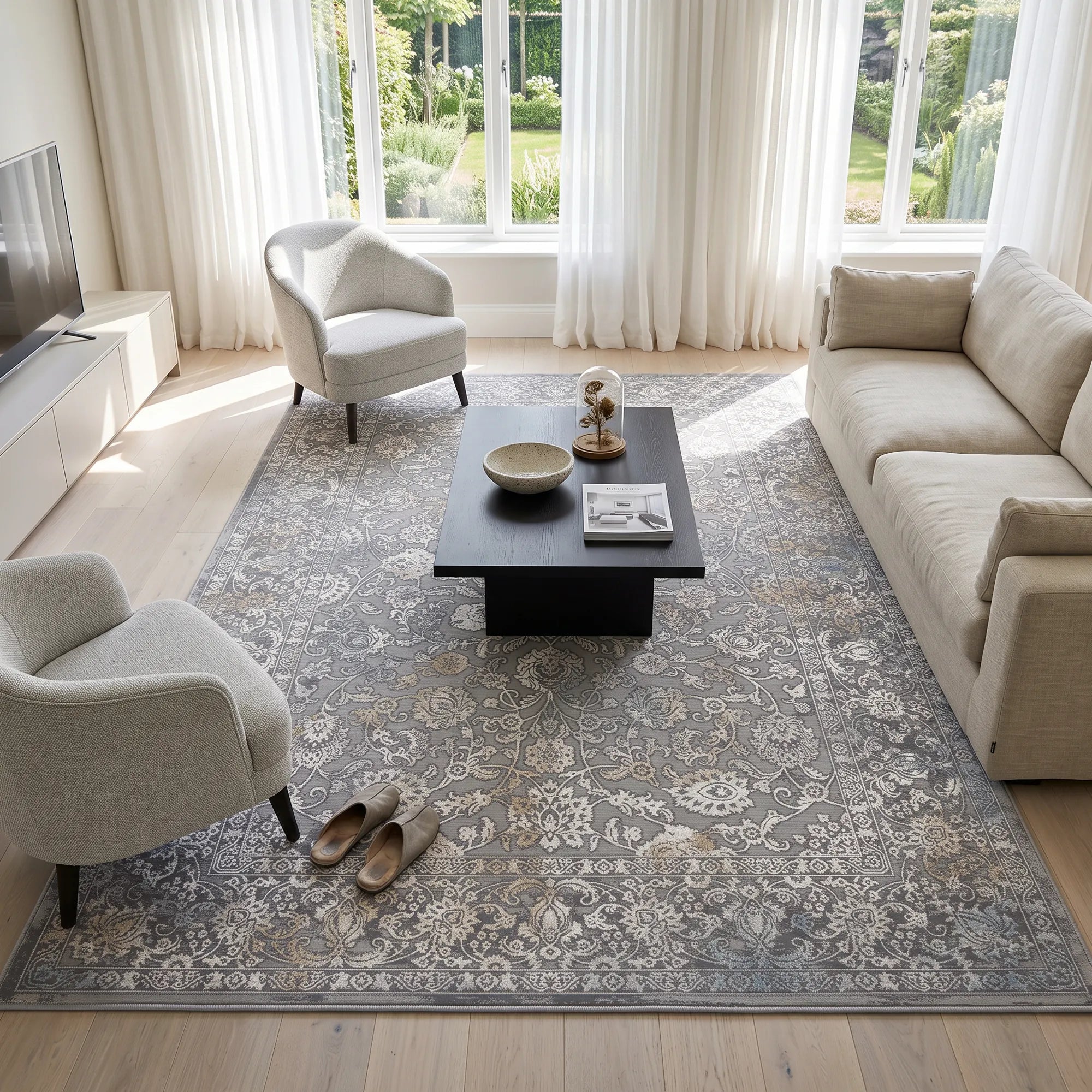 A stylish gray rug in a bright living room. there is couch, armchairs and wooden coffee table with TV unit.