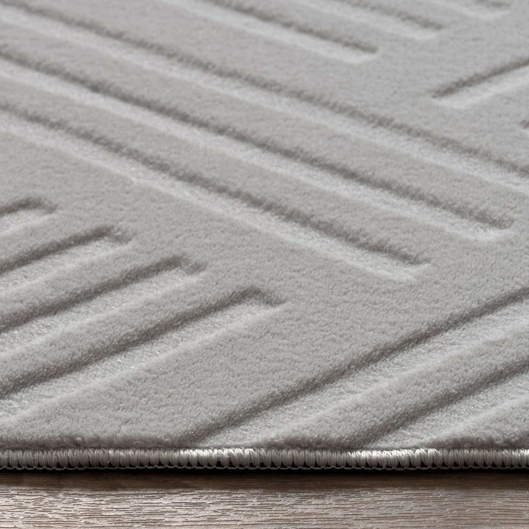 Світло-сірий плюшевий килим із геометричним візерунком лабіринту