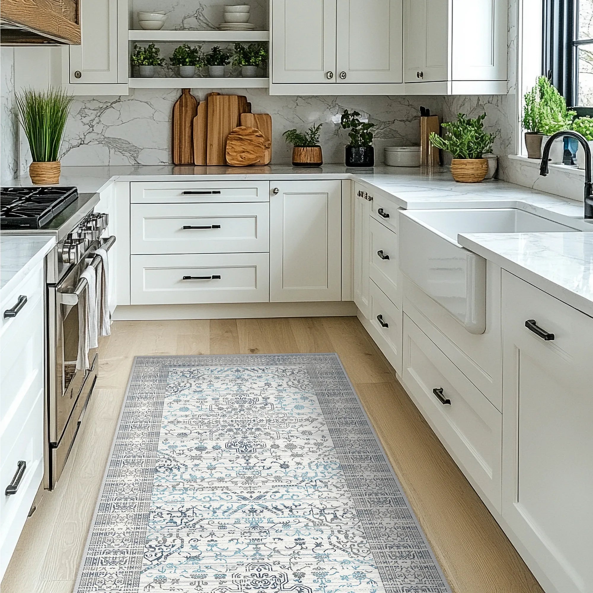 Modern kitchen with white cabinets, marble countertop, and decorative rug on wooden floor.