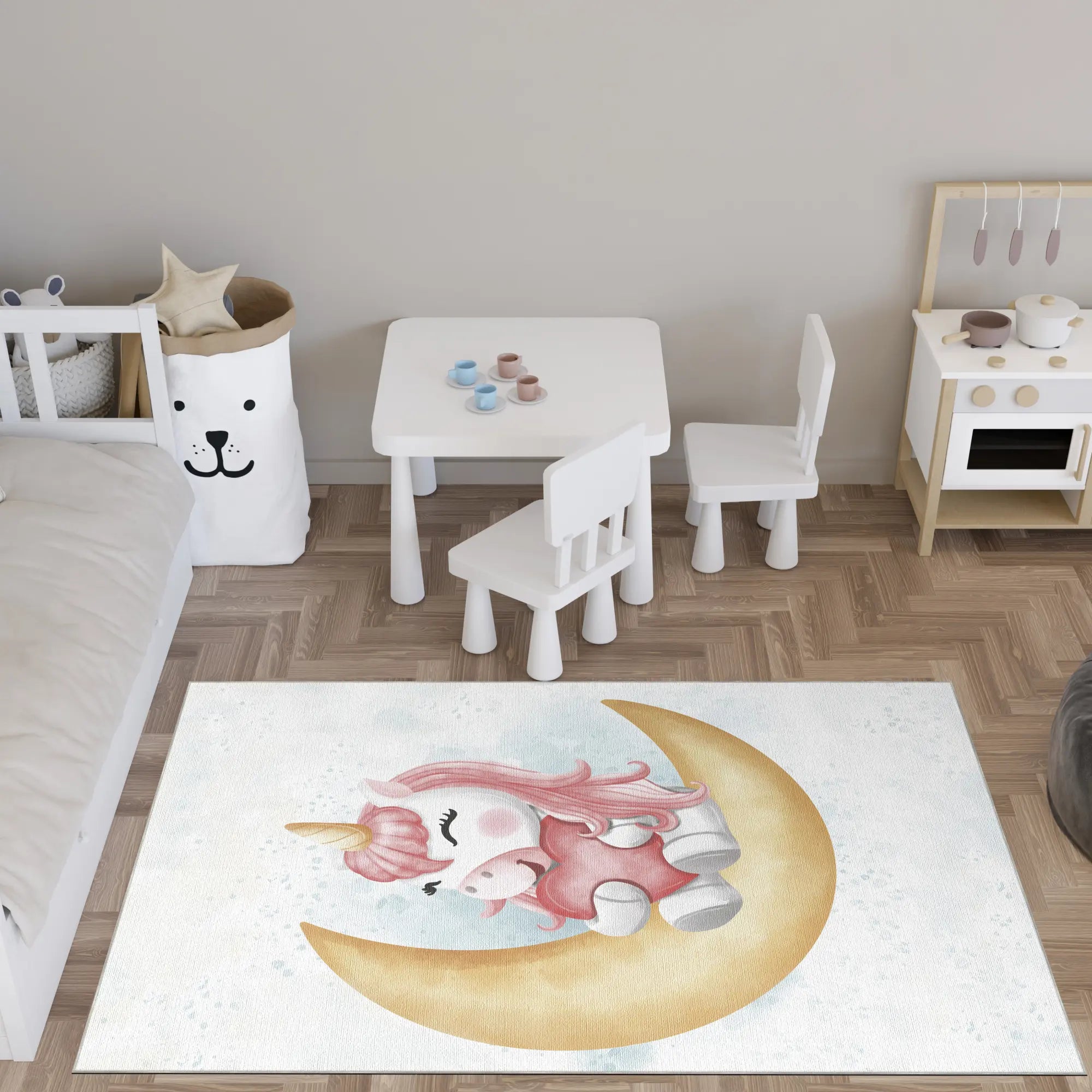 Children's room with a unicorn rug on the floor, white table and chairs, and a small bed.